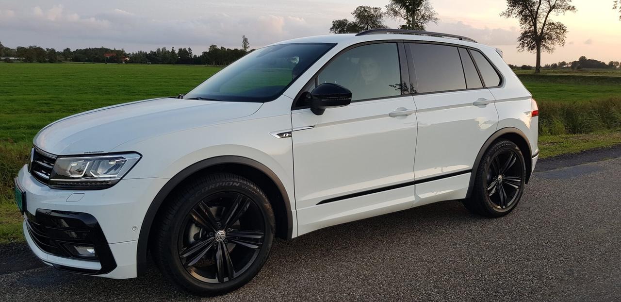 De witte Volkswagen Tiguan lesauto op een Friese polderweg